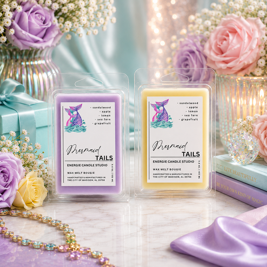 Two wax melt packages labeled 'Mermaid Tails' with decorative flowers and a gift box in the background.