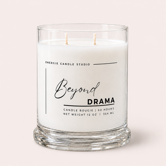 A two-wick glass jar candle with white wax and a clear glass base, featuring a white label with black text that reads 'Beyond Drama' and 'Energize Candle Studio,' on a light beige background.