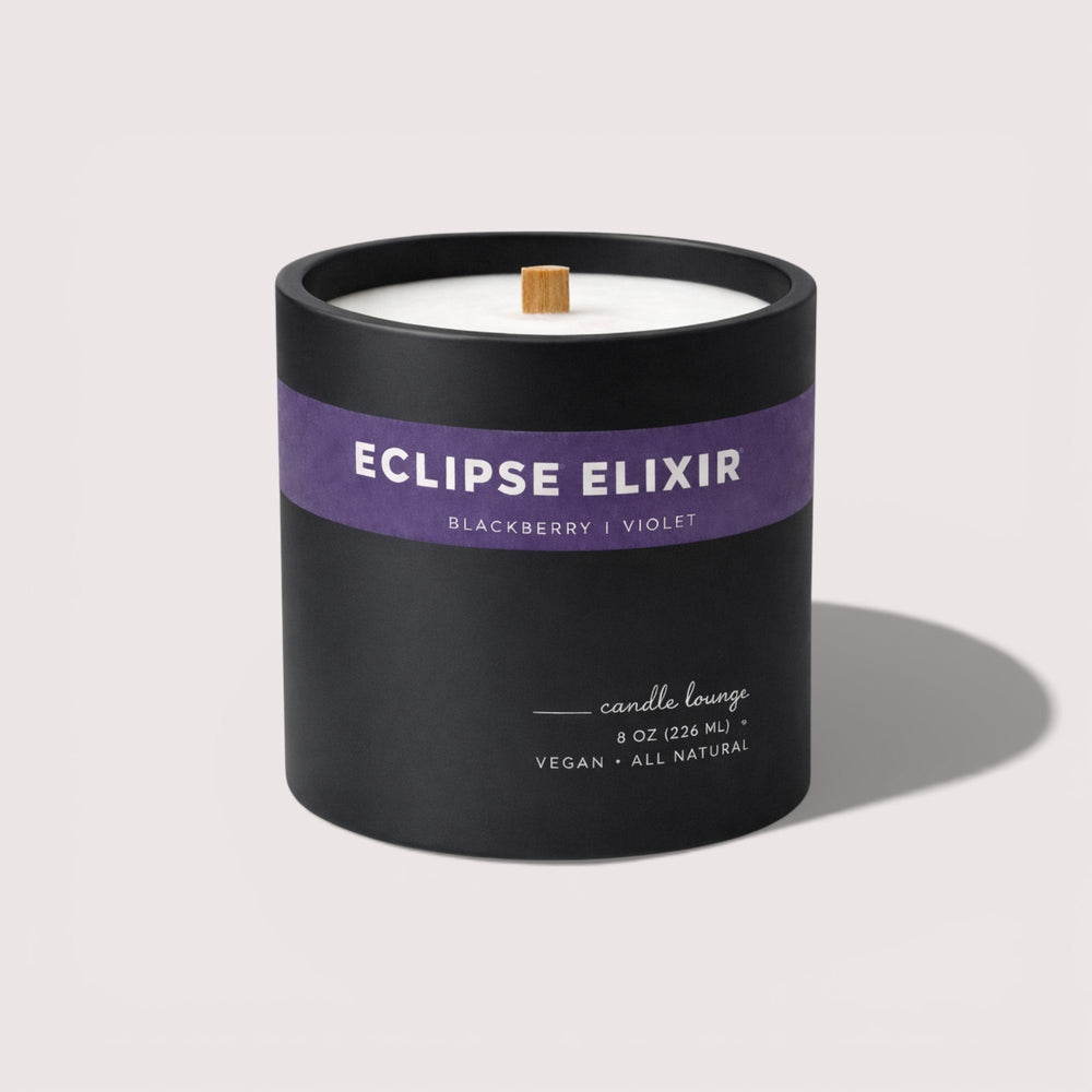 Black candle with a purple label on a white background