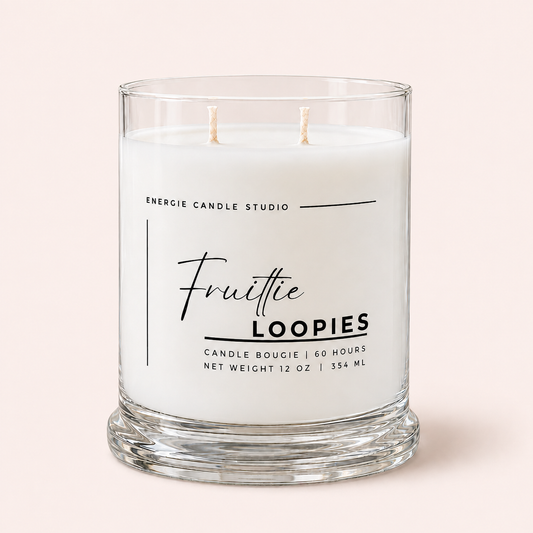 A two-wick scented candle in a clear glass jar with a thick base, featuring a white label that reads 'Energie Candle Studio' and 'Fruittie LOOPIES' on a pale pink background.