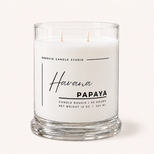 A two-wick scented candle in a clear glass jar with white wax, labeled 'Havana PAPAYA' by Energie Candle Studio, on a light cream background.