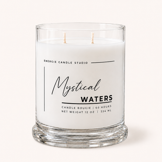 A two-wick scented candle in a clear glass jar with white wax, featuring a minimalist black label that reads 'ENERGIE CANDLE STUDIO' and 'Mystical Waters'.