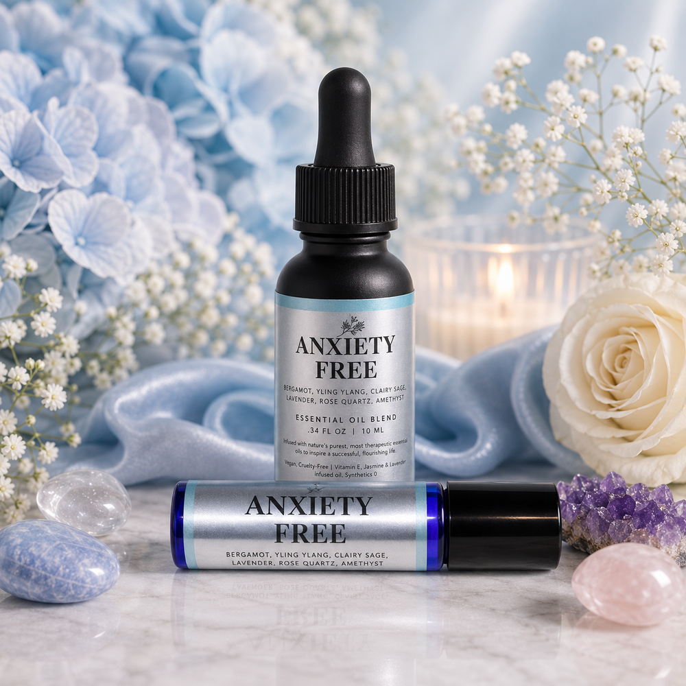 Anxiety Free Essential Oil Blend set, featuring a 30 mL dropper bottle and a 10 mL roller bottle with black caps and silver-blue labels, styled on a marble surface with blue hydrangeas, a white rose, crystals, and a candle in the background.