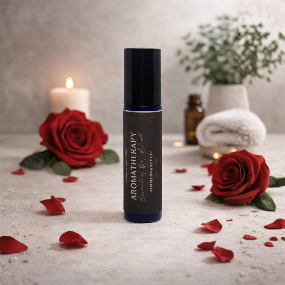 Aromatherapy essential oil roller bottle with red roses and candles on a textured surface