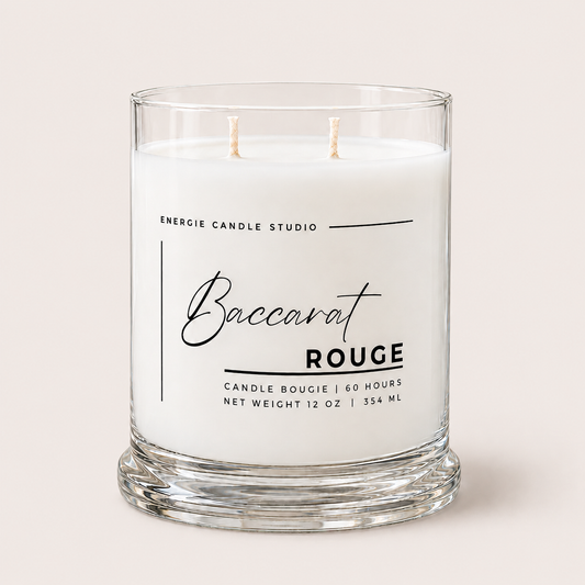 A two-wick scented candle in a clear glass jar with a thick base, featuring a white wax label that reads 'Baccarat ROUGE' and 'ENERGIE CANDLE STUDIO' on a light beige background.