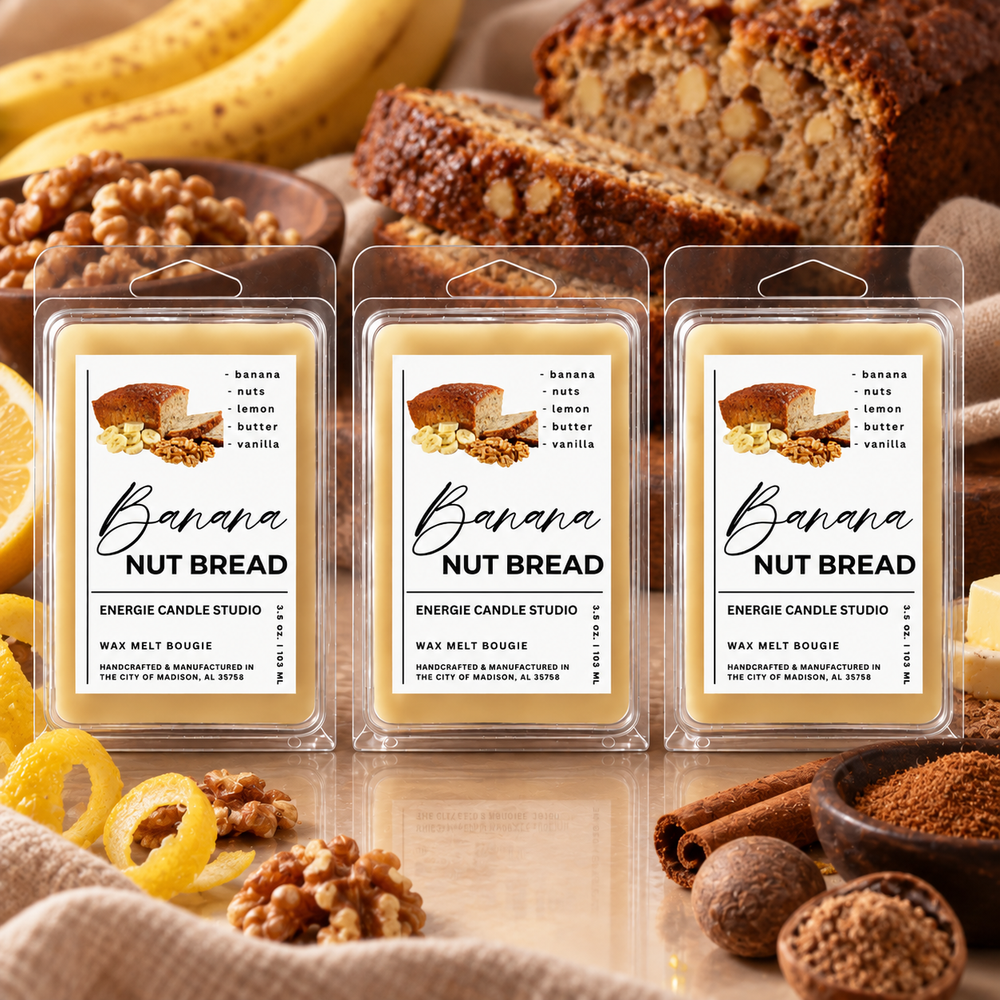 Three packaged wax melts labeled Banana Nut Bread are arranged on a tabletop with banana slices, walnuts, cinnamon sticks, and sliced bread in the background, creating a food-themed product scene.