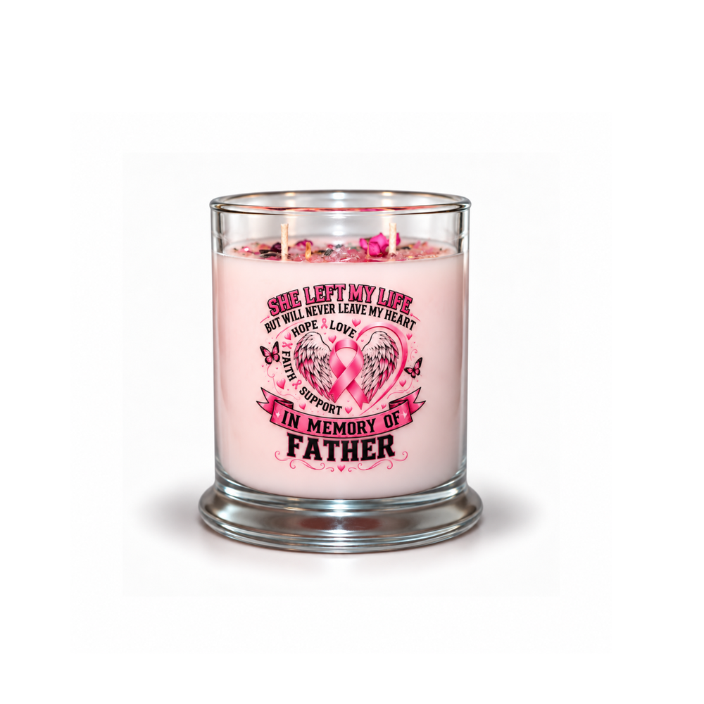 A pink memorial candle in a clear glass jar with a metal base, featuring a printed pink ribbon design and the text 'She left my life but will never leave my heart.