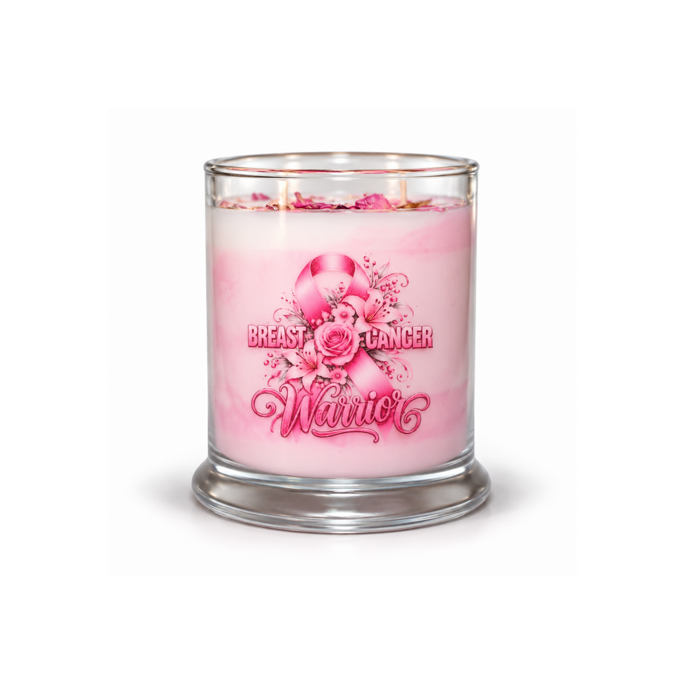 A pink scented candle in a clear glass jar with a thick glass base, featuring a pink rose and ribbon graphic with the text 'Breast Cancer Warrior' on the front, set against a plain white background.