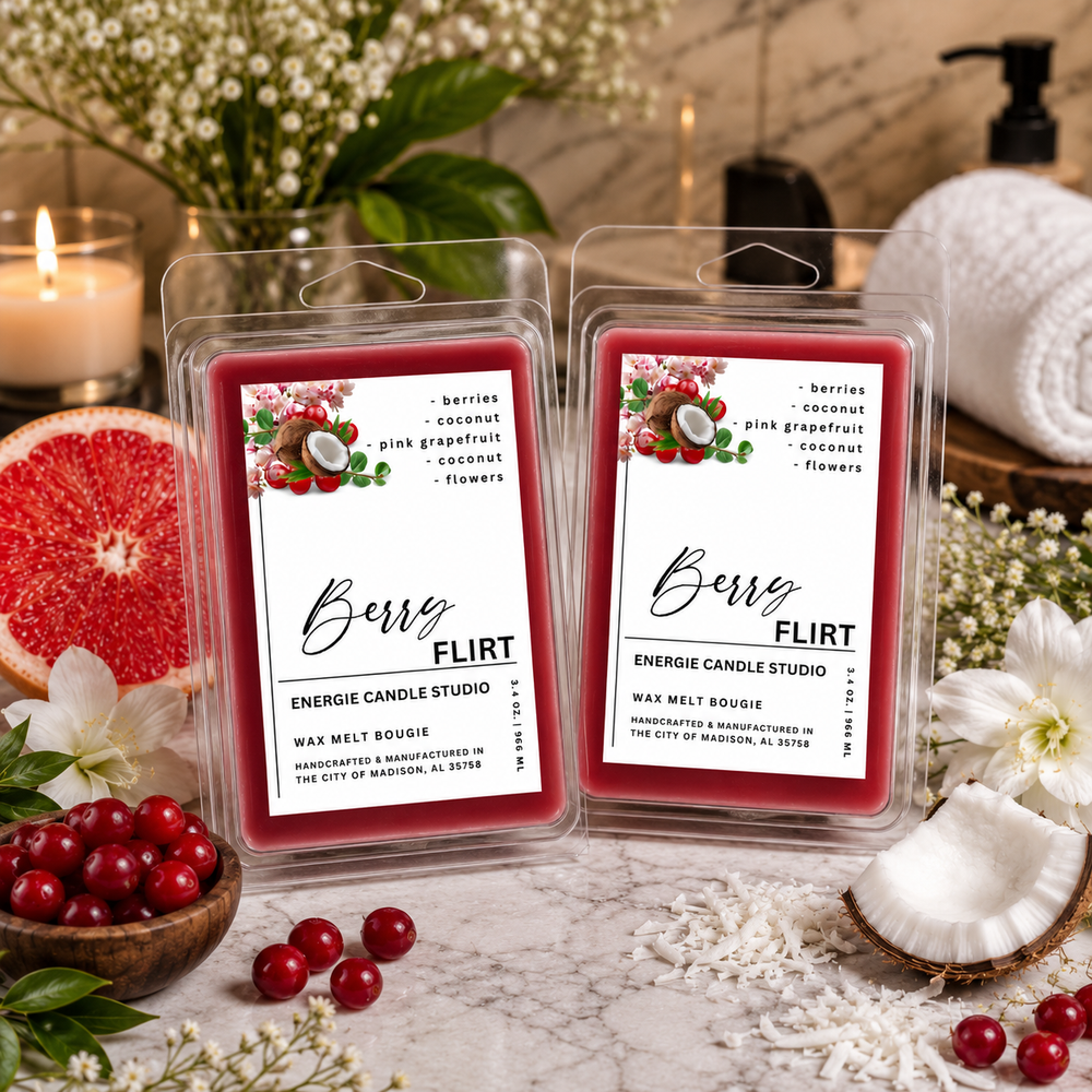 Two wax melts in clear clamshell packs labeled Berry Flirt, placed on a marble surface with berries, flowers, candles, and fruit props around them. The product packaging is the main subject, with a styled spa-like background.