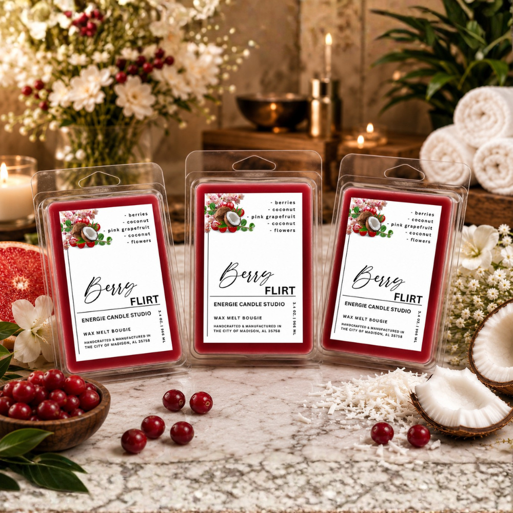 Three wax melt packages labeled Berry Flirt are arranged on a tabletop with cranberries, flowers, candles, and coconuts in a styled indoor setting.