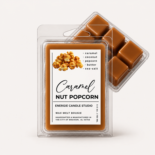 Two clear plastic wax melt clamshells on a light warm-gray background. The front package shows a caramel nut popcorn scent label with a photo of popcorn and the text 'Caramel Nut Popcorn' and 'Energie Candle Studio.