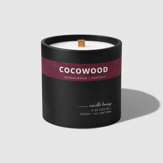 Cocowood candle with black container and maroon label on a light gray background