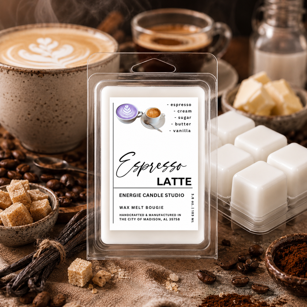 A packaged wax melt product labeled 'Espresso Latte' from Energie Candle Studio, shown in a clear clamshell with white wax cubes inside. The package is photographed in a styled coffee-themed setting with cups of latte, coffee beans, brown sugar, vanilla beans, and butter around it.