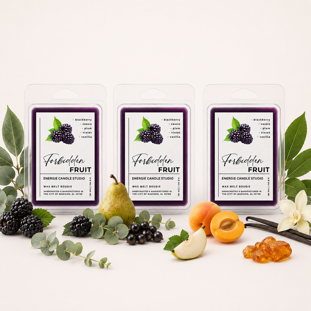 Three wax melt packages labeled Forbidden Fruit are arranged on a light neutral background with fruit and botanical props including blackberries, a pear, peaches, vanilla beans, and eucalyptus leaves.