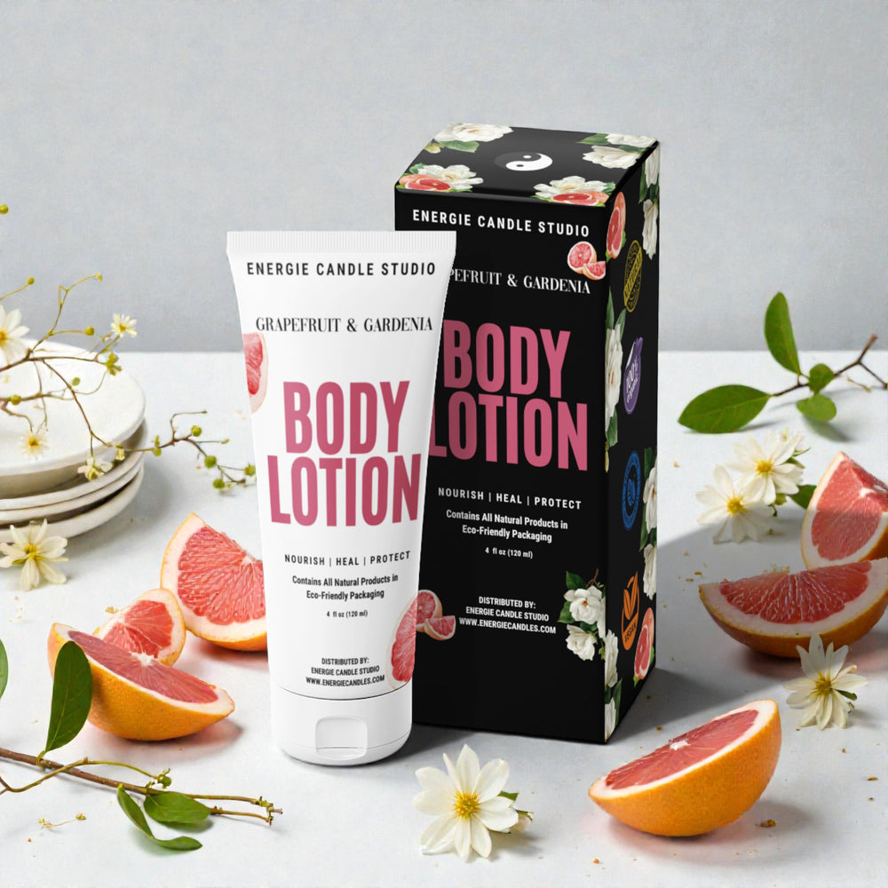 Energie Candle Studio body lotion with packaging on a table with grapefruit slices and flowers.