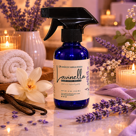 Blue spray bottle labeled 'Lavinella' surrounded by lavender flowers and candles on a wooden surface.