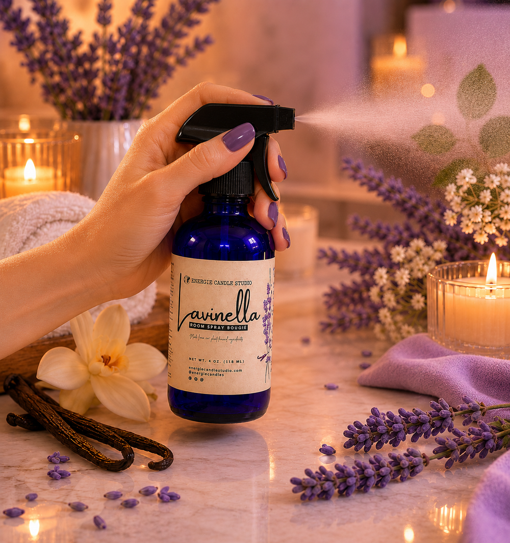 Hand holding a blue spray bottle labeled 'Lavinella' with lavender and candles in the background