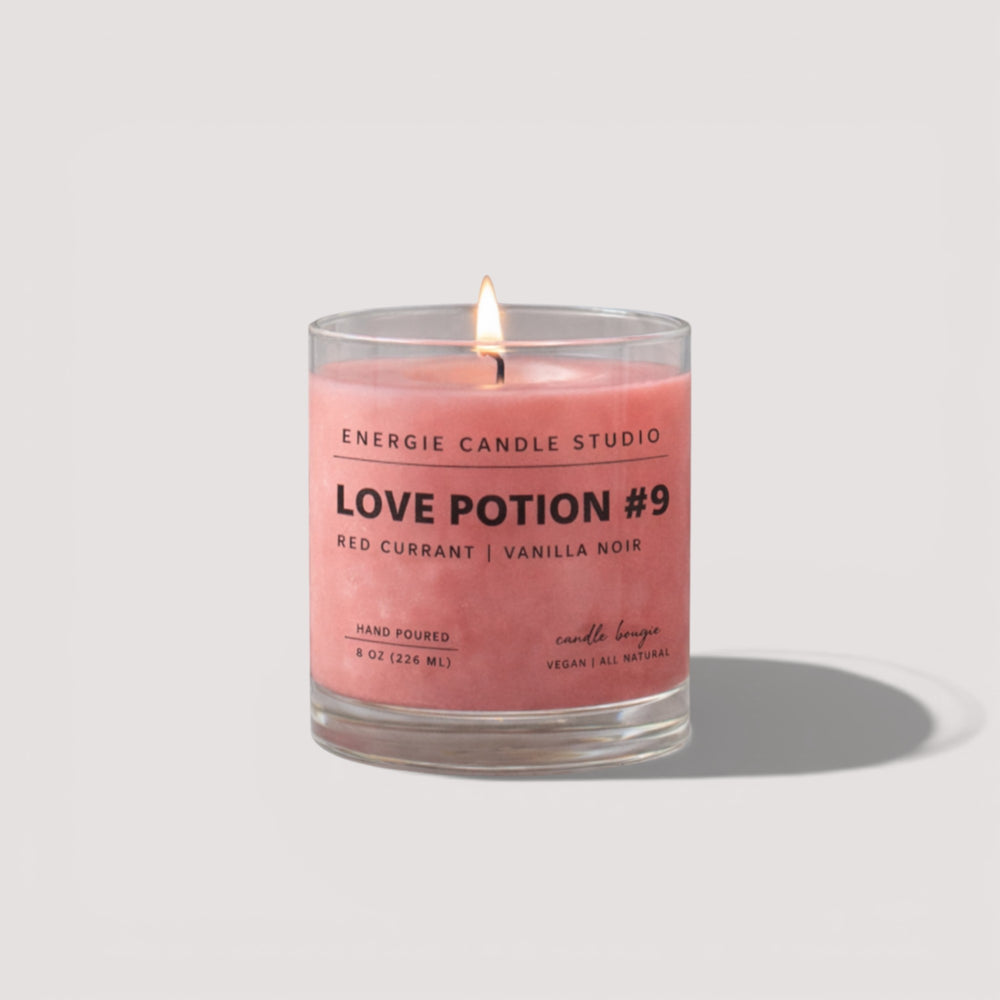 Pink candle in a glass jar with 'Energie Candle Studio' label on a light gray background