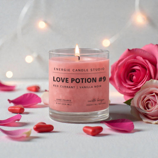 Pink candle labeled 'Love Potion #9' with roses and petals on a light background