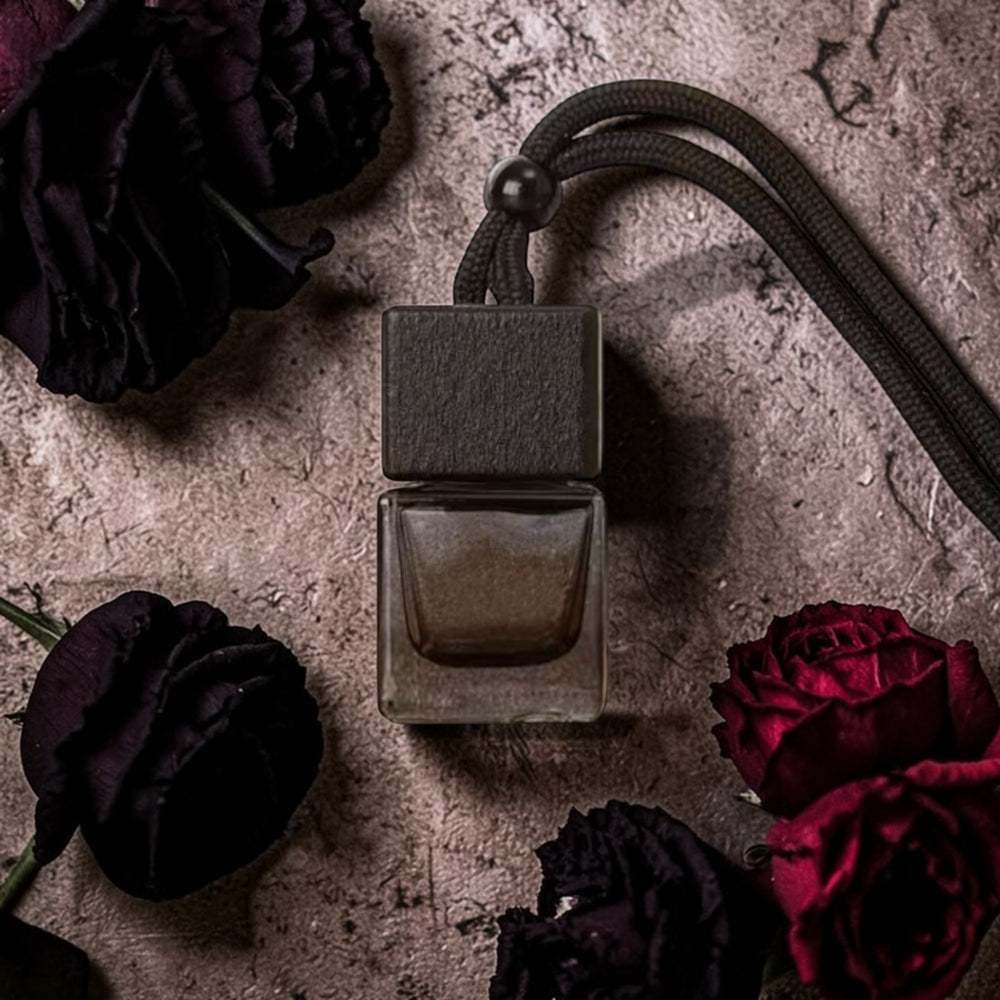 Perfume bottle with dark flowers on a textured surface