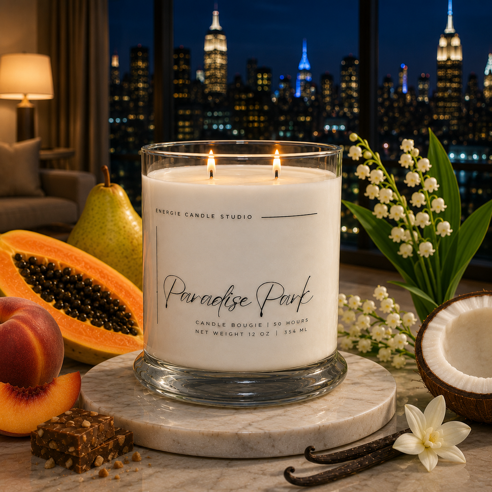 Candle labeled 'Paradise Park' on a marble surface with fruits and flowers, city skyline in the background