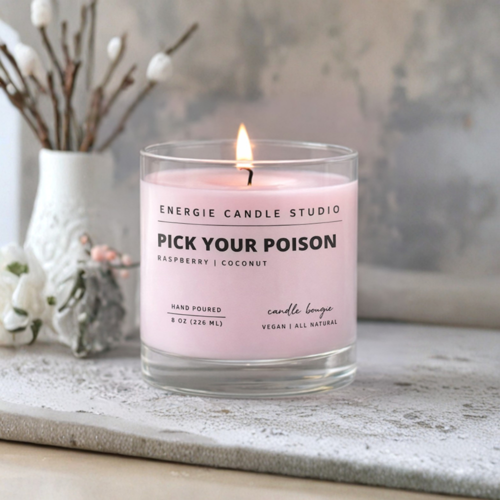 Candle with 'Pick Your Poison' label on a surface with decorative elements