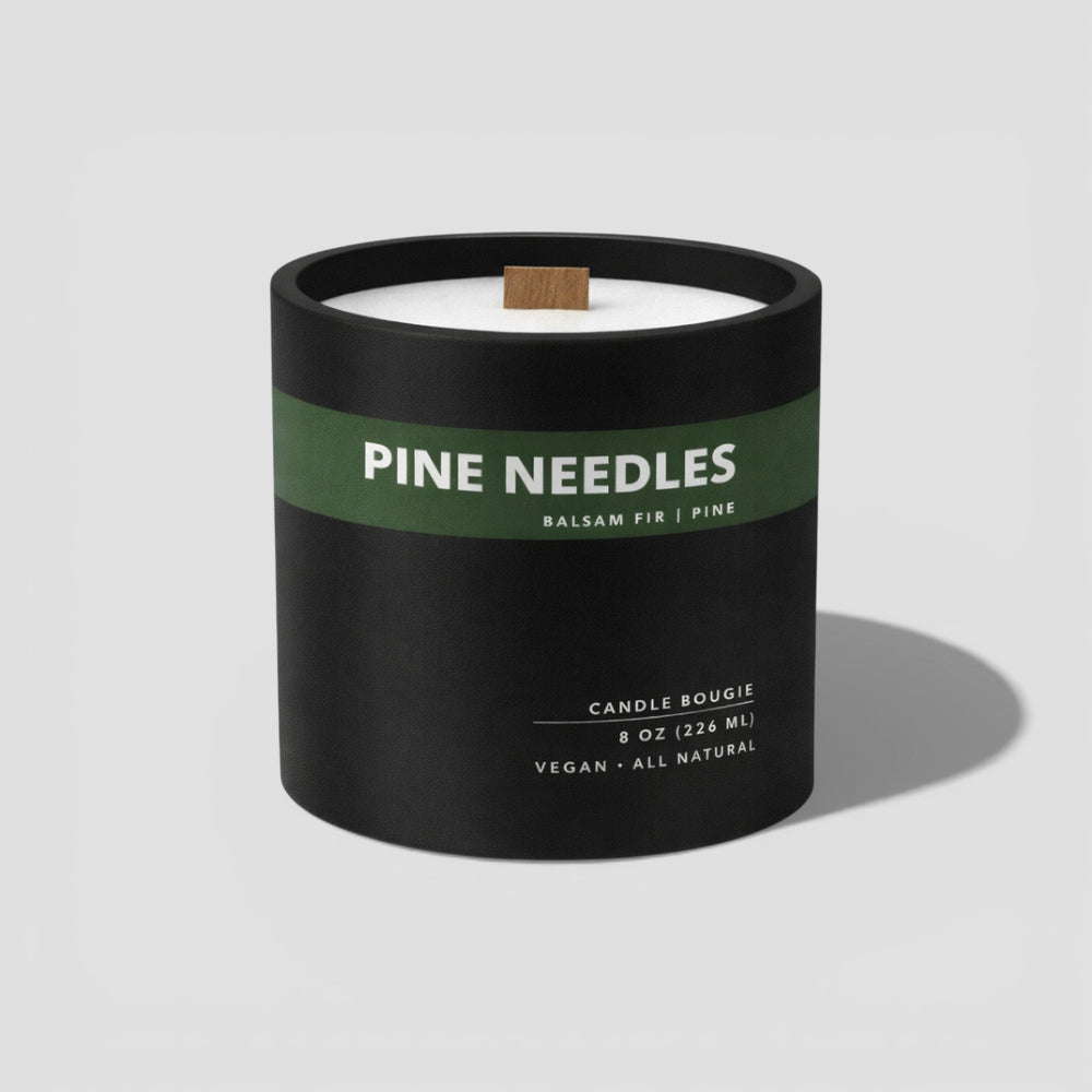 Candle with 'Pine Needles' label on a light gray background