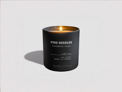 Black candle labeled 'Pine Needles' on a white background