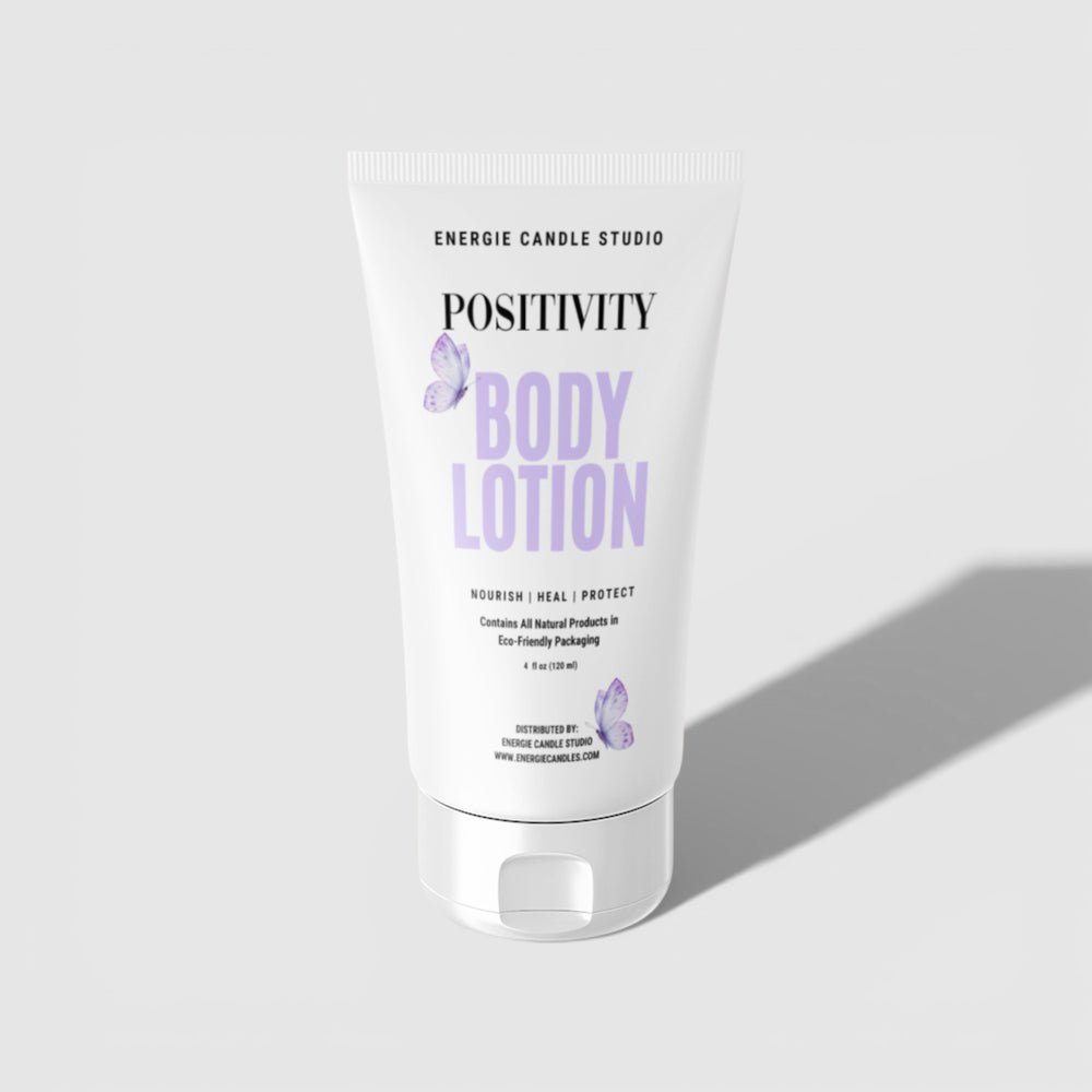 Body lotion tube labeled 'Positivity' by Energie Candle Studio on a light gray background