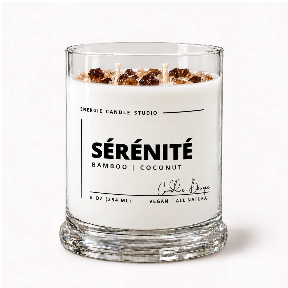 A glass jar candle with white wax and three wicks, topped with brown and beige decorative elements. The clear glass jar has a white label reading 'ENERGIE CANDLE STUDIO SÉRÉNITÉ BAMBOO | COCONUT' on a clean white background.