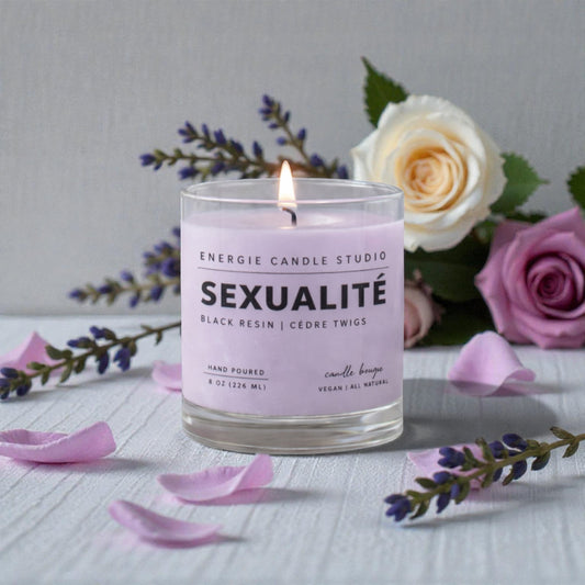 Candle labeled 'Sexualite' from Energie Candle Studio with flowers in the background