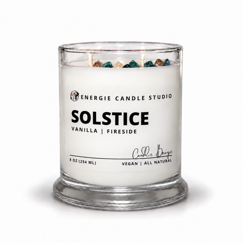 An 8 oz glass jar candle by Energie Candle Studio, featuring a white wax fill, three wicks, decorative multicolor stones at the top, and a clear glass base on a white background.