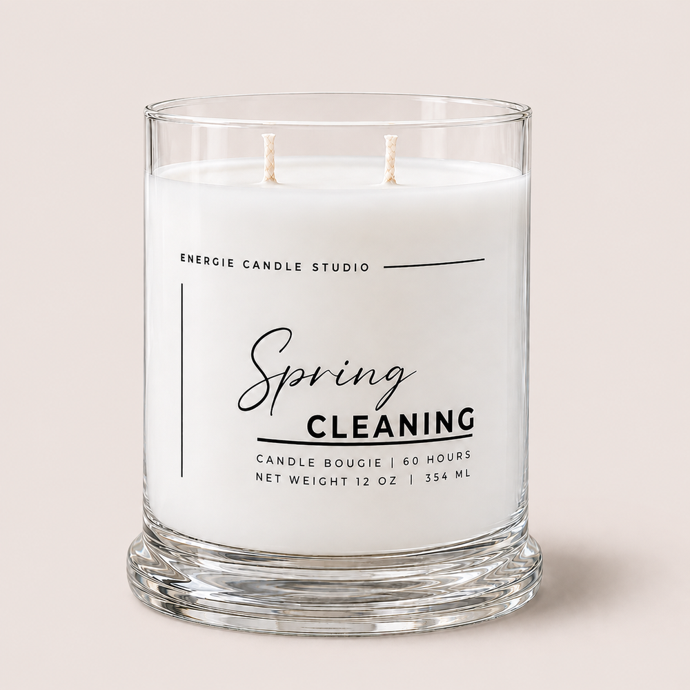 A two-wick glass jar candle labeled 'Spring Cleaning' by Energie Candle Studio, filled with white wax and set against a solid light beige background.