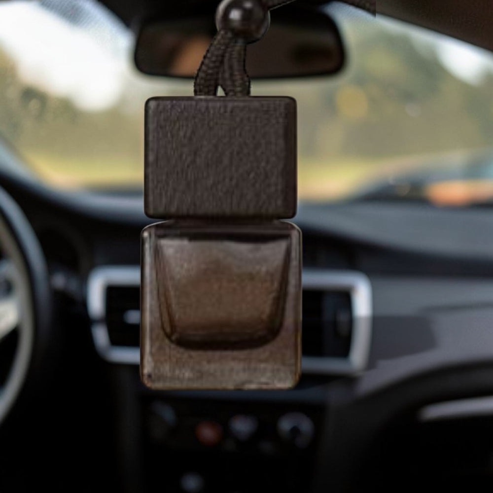 Brown leather car air freshener hanging from a car's rearview mirror.