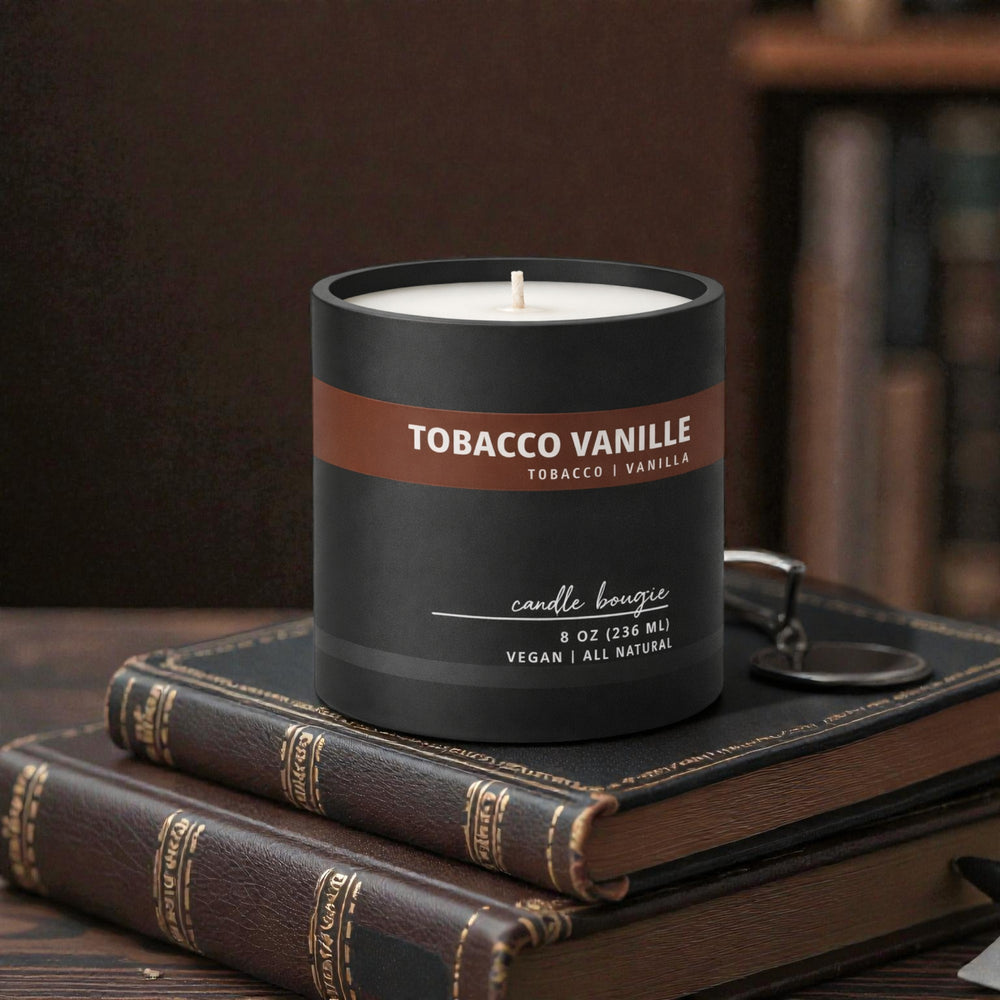 Candle labeled 'Tobacco Vanille' on top of vintage books with a blurred bookshelf in the background.