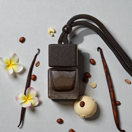 Perfume bottle with vanilla beans, flowers, and a macaron on a light gray background