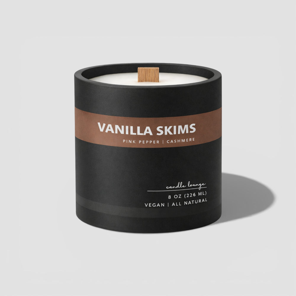 Vanilla Skims candle in a black container on a light gray background