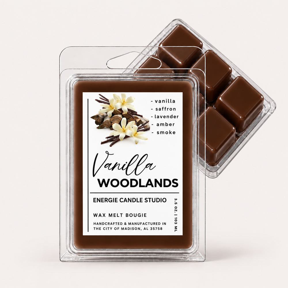 Two clear plastic clamshell wax melt packages on a clean white background. The front package is labeled 'Vanilla Woodlands' by Energie Candle Studio and contains dark brown wax cubes.
