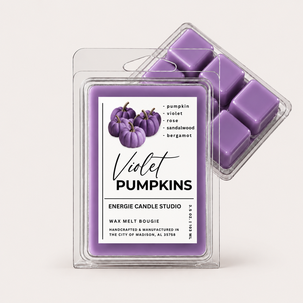 Two clear plastic wax melt clamshells on a light warm gray background. The front package contains a single square wax melt with a white label reading 'Violet Pumpkins' and listing scent notes: pumpkin, violet, rose, sandalwood, and bergamot.