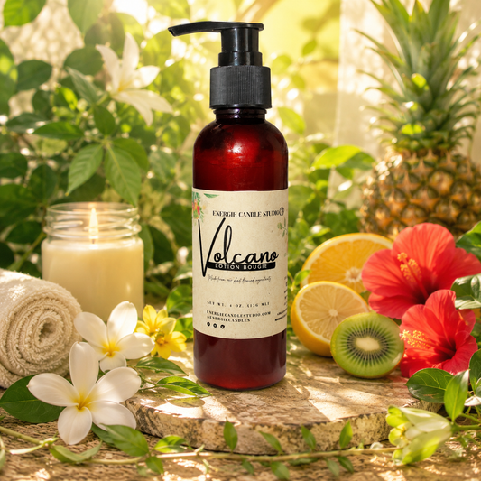 Bottle of Volcano body wash with a candle, lemons, kiwi, and flowers on a wooden surface with a natural background.