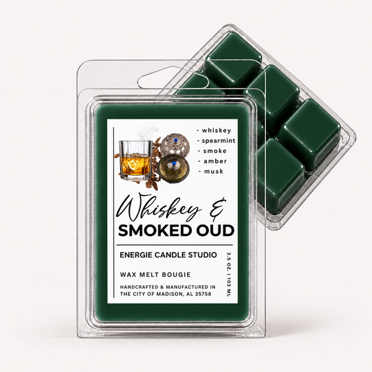 A clear plastic clamshell package of Energize Candle Studio Whiskey & Smoked Oud wax melts, with a front label and a second package behind it showing dark green wax pieces.